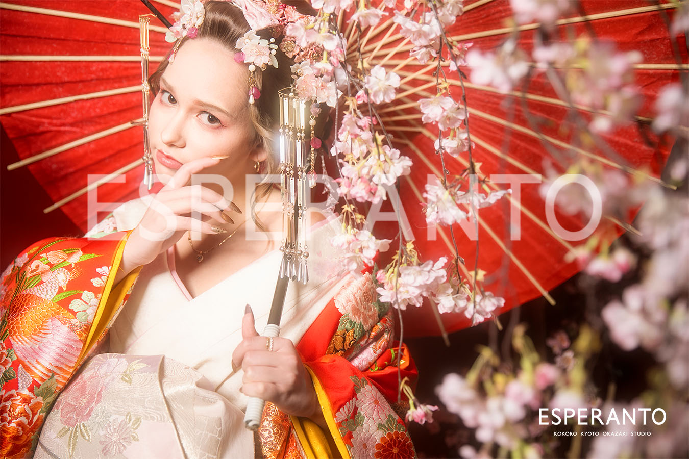 Guest posing in a vivid red uchikake for a Kyoto makeover photoshoot