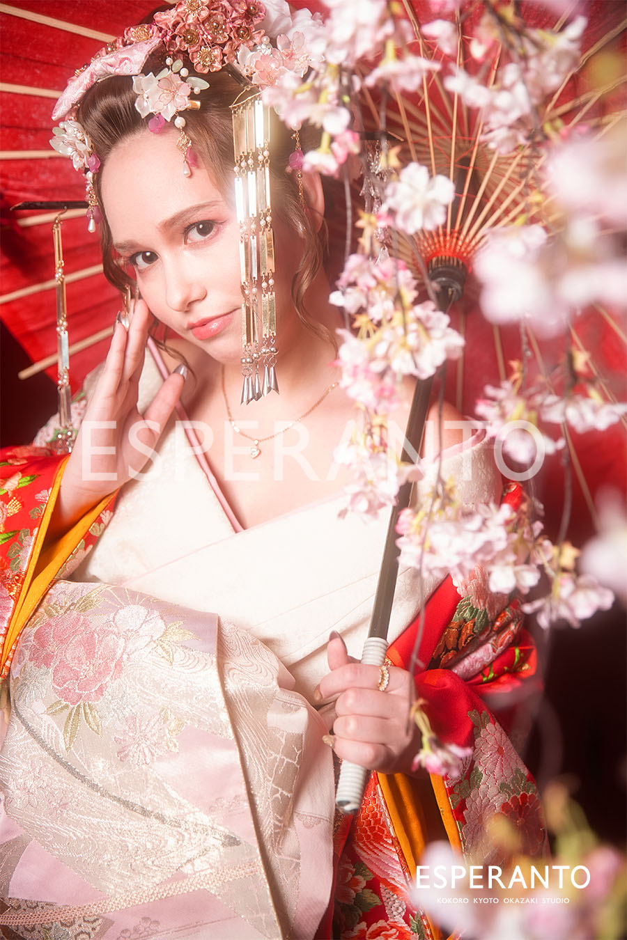 Guest wearing a pale pink kimono with cherry blossom hair ornaments in Kyoto